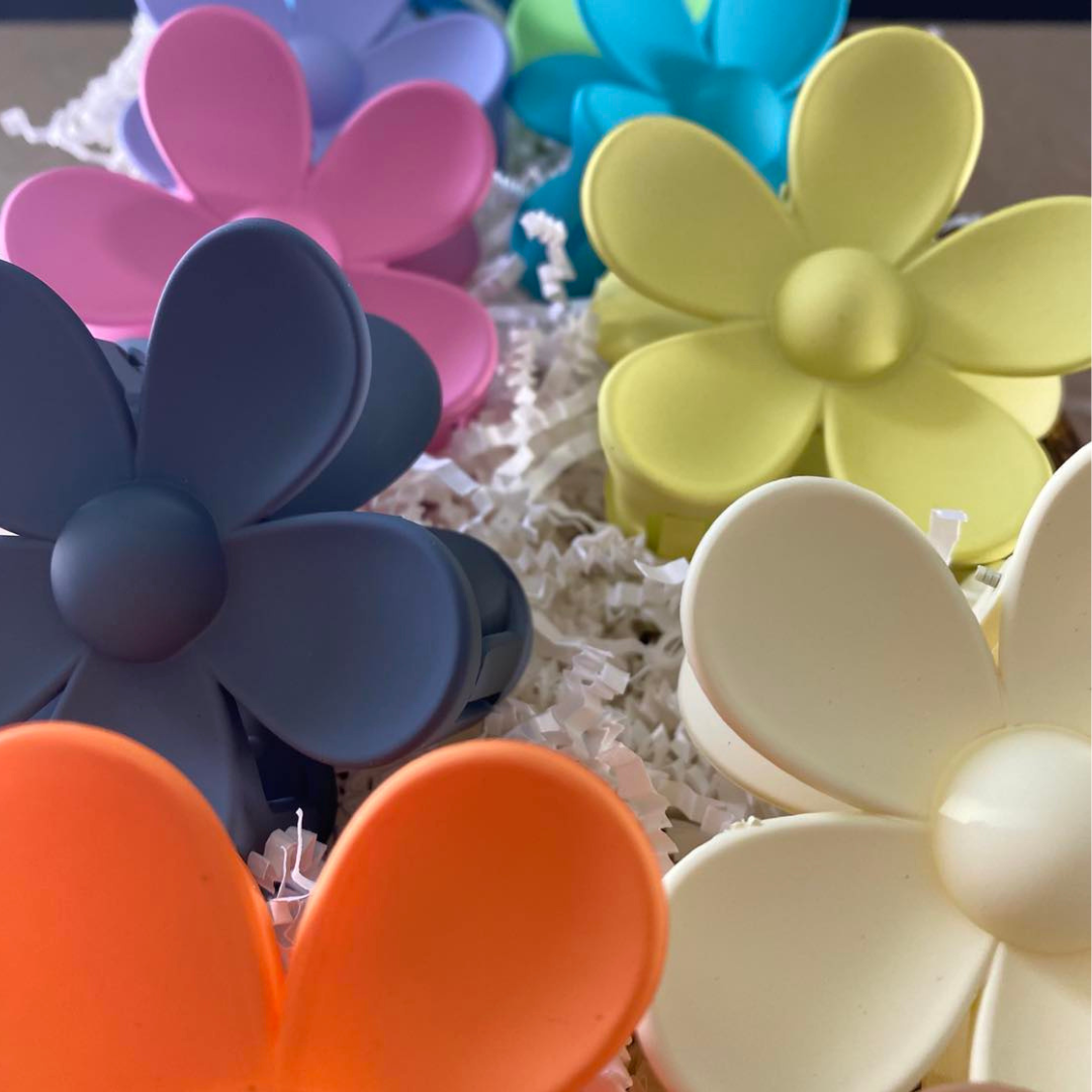 cover photo showing large flower shaped hair clips in black, orange, white, yellow, pink, blue